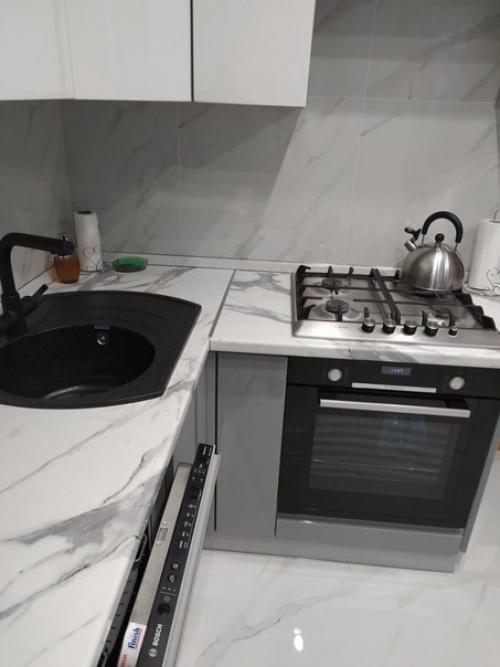 Серая кухня с имитацией мрамора на полу, столешнице и фартуке. 01