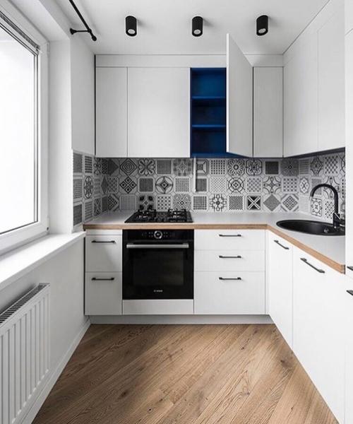 Белая кухня с орнаментом на фартуке.